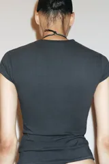 Camiseta de corte entallado confeccionada en mezcla de algodón, con cuello redondo y mangas cortas. Presenta un diseño básico de bajo recto en color gris oscuro.