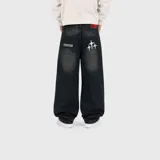 Pantalón jean baggy de color negro con efecto acid wash, corte holgado y diseño de tiro medio. Cuenta con bolsillos traseros con detalles bordados en hilo blanco y etiqueta roja en la parte posterior.