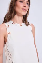 Blusa negra sin mangas, de corte recto y escote redondo, con detalles de bordados contrastantes en color blanco en los bordes y costados.