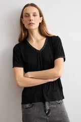 Remera negra de manga corta con escote en V y sutil detalle de lurex brillante en el cuello y las mangas.