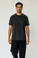 Remera de algodón color gris oscuro con cuello redondo y detalle de líneas blancas en los hombros que se extienden hacia las mangas.