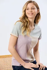 Remera de manga corta con diseño de bloques de color en tonos verde menta, beige y lila, corte clásico y cuello redondo.