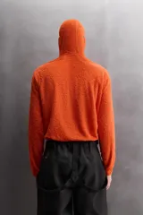Sudadera de corte regular fit confeccionada en tejido polar con textura efecto pelo. Presenta cuello subido con capucha integrada, manga larga ranglán y acabados con cinta elástica. El bajo es asimétrico, siendo más largo en la parte posterior.
