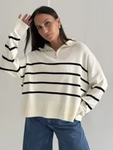 Sweater estilo chomba con cierre frontal, confeccionado en tejido bremer rayado de manga larga. Presenta un diseño amplio y moderno con cuello polo.