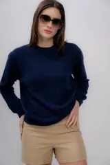 Sweater gris de tejido de punto, con cuello redondo y mangas largas.