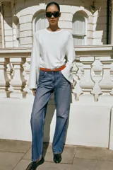 Jeans de tiro alto y corte recto de pernera larga, con diseño clásico de cinco bolsillos y costuras en contraste. Cierre frontal con cremallera y botón metálico.