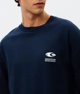 Remera de corte oversized color azul marino, con cuello redondo y mangas cortas. Presenta un estampado gráfico grande en la espalda con el texto 'Innovation Research' y diversos elementos visuales de estilo tecnológico.