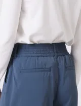 Pantalón palazzo de tiro alto en color verde militar, con diseño de doble abotonadura frontal, pinzas en la cintura y pierna ancha. Cuenta con cintura elástica en la parte posterior para mayor ajuste y bolsillos laterales funcionales.