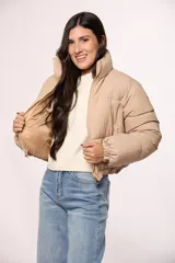 Campera puffer corta de nylon, color beige, con cuello alto, cierre frontal y puños elásticos.