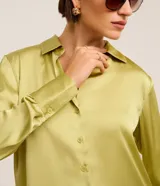 Camisa de satén azul marino, con cuello inglés, manga larga y cierre frontal con botones.
