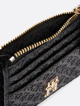 Tarjetero Tommy Hilfiger negro con diseño integral del monograma TH en bajo relieve. Cuenta con un compartimento principal con cremallera y múltiples ranuras exteriores para tarjetas.