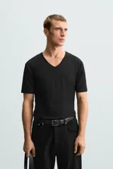 Camiseta blanca de algodón con elasticidad, corte slim fit, cuello en V y mangas cortas.