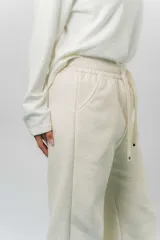 Pantalón deportivo de corte wide leg con caída relajada. Presenta cintura elastizada con cordón ajustable, bolsillos laterales y un interior frizado para mayor abrigo.