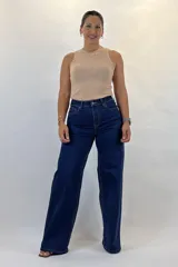 Pantalón de denim azul oscuro de corte wide leg y tiro alto. Cuenta con cinco bolsillos, cierre frontal con cremallera y botón, y está confeccionado con lycra para un ajuste cómodo.
