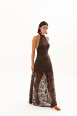 Vestido largo de encaje color chocolate, con escote halter y diseño ajustado en el torso que se abre en una falda con transparencia en el ruedo.
