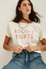 Remera de algodón color crudo con estampa frontal multicolor con la frase 'BOOGIE NIGHTS' en tipografía con efecto arcoíris. Presenta mangas ranglan y cuello redondo.