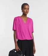 Blusa fucsia de viscolycra crepada, con escote en V y mangas cortas con detalle de pliegues en los hombros.