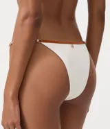 Bombacha de bikini colaless de color blanco con ribetes y tiras finas en tono marrón, confeccionada en microfibra con poliamida y elastano.