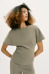 Top de cuello redondo y manga corta, con diseño liso y detalle de abertura (cut out) en la espalda.