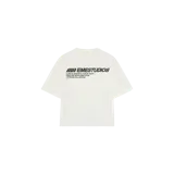 Remera oversize color beige de la marca Eme Studios, con mangas cortas y cuello redondo. Cuenta con un estampado gráfico en la espalda con el logo y texto en color verde oscuro.