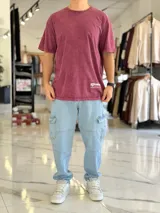 Remera oversize de color bordó con efecto gastado acid wash, mangas cortas y estampa en la espalda con texto y logo.