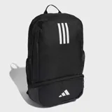 Mochila deportiva negra con tres franjas blancas verticales en el panel frontal y logo de Adidas Badge of Sport blanco en el bolsillo inferior. Posee un compartimento inferior con cierre para calzado y bolsillos laterales de malla.