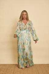 Vestido largo con estampado floral en tonos verde agua y detalles metalizados dorados, con escote en V, mangas largas abullonadas y falda de diseño escalonado.