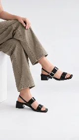 Sandalia de cuero color beige con taco cuadrado de 4 cm, tiras delanteras, tira ajustable con hebilla metálica dorada y tira elástica trasera.