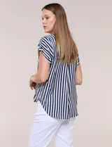 Camisa de calce holgado color blanco con rayas verticales negras, cuello camisero clásico, abotonadura frontal y mangas cortas.