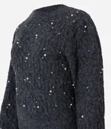 Buzo de tricot texturizado color gris con perlas blancas aplicadas. Tiene mangas largas abullonadas y cuello redondo.