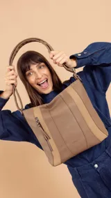 Cartera bandolera color marrón con detalles en gamuza. Tiene correa regulable, cierre metálico frontal y trasero, y división interna.