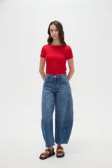 Pantalón de jean blanco de tiro medio, con diseño de silueta barrel, bolsillos clásicos y costuras con pinzas decorativas en la zona de las rodillas.