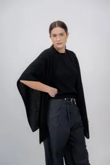 Ruana negra de tejido de punto grueso, confeccionada en 100% baby alpaca.