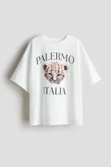 Remera oversized de algodón blanca con estampado frontal de la cara de un cachorro de leopardo y las inscripciones "Palermo" e "Italia".