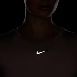 Remera deportiva Nike de manga corta, con cuello redondo y detalle de nudo frontal. Presenta un diseño corto y logo de la marca bordado en el centro del pecho.