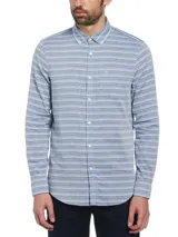 Camisa de hombre de manga larga con rayas horizontales en tonos celeste, gris y blanco. Tiene cuello abotonado, bolsillo en el pecho y cierre con botones. Marca Original Penguin.