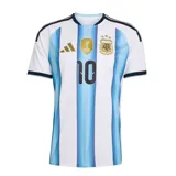 Camiseta de fútbol Adidas de la selección argentina, modelo Home, con el número 10 y el nombre "MESSI" en la espalda (no visible en la imagen, pero inferido por el título). Diseño a rayas verticales celestes y blancas, con logo de Adidas y escudo de la AFA en el pecho, además del parche de campeón del mundo FIFA 2022.