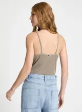 Body de punto color beige con hilos metálicos, escote en V cruzado y tirantes finos.