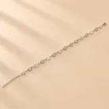 Pulsera de plata 925 con diseño de eslabones intercalados que combinan pequeñas flores de cuatro pétalos y círculos abiertos.