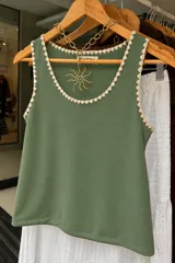 Musculosa de morley verde militar con escote redondo y detalles de bordado artesanal en crochet en los bordes.