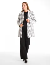 Cardigan de tejido soft con estampado de espiga en blanco y negro, corte recto, manga larga y bolsillos frontales amplios.