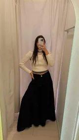 Pantalón palazzo negro de tiro alto con pinzas delanteras y bolsillos laterales.