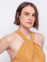 Top verde oliva sin mangas con cuello halter y nudo en el escote.