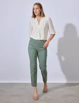 Pantalón de vestir verde esmeralda, de corte recto, con bolsillos laterales y traseros.