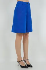 Bermuda de gamuza color azul, de corte recto y tiro alto, con bolsillos laterales y terminación a la rodilla.