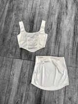 Conjunto de dos piezas confeccionado en tela satinada color azul vibrante. Incluye un top tipo corset con escote cuadrado y una minifalda ajustada de tiro alto.