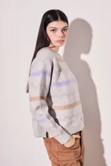 Sweater gris melange de punto con cuello redondo y mangas largas. Presenta rayas horizontales en tonos marrón y lila.
