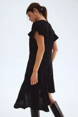 Vestido corto negro de crepé de viscosa con escote redondo y abertura de cerradura con botón oculto atrás. Presenta mangas mariposa, costuras diagonales en el torso y una pollera asimétrica con vuelo.