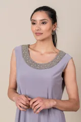 Vestido corto lila con bordado de lentejuelas en el escote, con chaqueta de tul a juego de mangas 3/4.