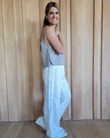 Pantalón de algodón color arena, de corte recto y holgado, con cintura elástica y detalle de costuras horizontales decorativas en la parte inferior de las piernas.